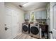 Modern laundry room featuring stainless steel washer and dryer, light-colored cabinets and ample storage at 383 Remington Dr, Oviedo, FL 32765