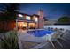 A backyard pool at dusk, surrounded by lush greenery, covered patio with a grill, and lounge seating at 383 Remington Dr, Oviedo, FL 32765