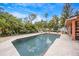 A private backyard pool surrounded by lush greenery, offering a tranquil retreat with outdoor seating at 383 Remington Dr, Oviedo, FL 32765