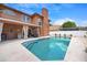 Sparkling in-ground pool with sundeck surrounded by manicured landscaping and a covered patio at 383 Remington Dr, Oviedo, FL 32765