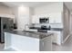 Modern kitchen featuring stainless steel appliances, white cabinets, and large island with sink and seating at 3971 Guernsey Bnd, St Cloud, FL 34772