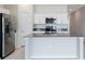 Bright kitchen with stainless steel appliances, white cabinets, and island with a stainless steel sink at 3971 Guernsey Bnd, St Cloud, FL 34772