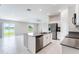 Modern kitchen featuring stainless steel appliances, white cabinets, and island overlooking the living room at 3971 Guernsey Bnd, St Cloud, FL 34772