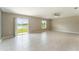 Spacious living room with tile floors, ceiling fan, and sliding glass doors with views of the pond at 3971 Guernsey Bnd, St Cloud, FL 34772