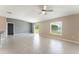 Open living area with tile floors, ceiling fan, and sliding glass doors with views of the pond at 3971 Guernsey Bnd, St Cloud, FL 34772