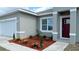 Charming home with fresh landscaping in front yard featuring mulch ground cover, decorative plants, and green grass at 475 Marion Oaks Mnr, Ocala, FL 34473
