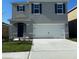 Two-story home featuring blue shutters, a two-car garage, and a well-manicured lawn at 4908 Kaia Ave, Winter Haven, FL 33884