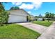 Single-story home with a two-car attached garage and a well-manicured lawn and driveway at 513 Dew Drop Cv, Casselberry, FL 32707