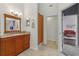 A bathroom showcasing a well-lit vanity and an open doorway leading to a comfortable living space at 6057 Lake Pointe Dr # 408, Orlando, FL 32822
