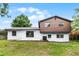 Home's exterior featuring a simple concrete patio and a mix of white and brown siding at 7085 Willowwood St, Orlando, FL 32818