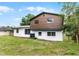A spacious backyard features a simple concrete patio, with a mix of white and brown siding at 7085 Willowwood St, Orlando, FL 32818