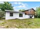View of the white and brown two-story home featuring a simple concrete patio at 7085 Willowwood St, Orlando, FL 32818
