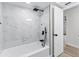 Bathroom showcasing a tub with elegant white marble tile and sleek, dark fixtures at 7085 Willowwood St, Orlando, FL 32818