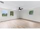 Sunny bedroom features light wood floors, a ceiling fan, and three large windows at 7085 Willowwood St, Orlando, FL 32818