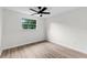 Bedroom featuring light wood-look flooring, and a view of lush trees through the window at 7085 Willowwood St, Orlando, FL 32818