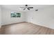 Bright bedroom featuring a ceiling fan, wood floors, fresh paint, and a window providing natural light at 7085 Willowwood St, Orlando, FL 32818