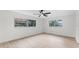 Bedroom with light wood-look flooring, two windows, and outside trees at 7085 Willowwood St, Orlando, FL 32818