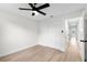 Bedroom featuring light wood-look floors, closet, view through doorway, with a modern ceiling fan at 7085 Willowwood St, Orlando, FL 32818