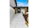Up-close of the front porch steps and front door with wood supports and black railing at 7085 Willowwood St, Orlando, FL 32818