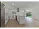 Open-concept living space with modern kitchen, island, stainless appliances, and access to outdoor patio at 7085 Willowwood St, Orlando, FL 32818