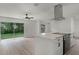 Bright kitchen with quartz island, stainless appliances, and slider to fenced yard at 7085 Willowwood St, Orlando, FL 32818