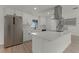Bright kitchen with white cabinets, stainless steel refrigerator, and spacious island with quartz countertops at 7085 Willowwood St, Orlando, FL 32818