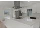 Bright kitchen featuring modern white cabinets, sleek countertops, and stainless steel range hood at 7085 Willowwood St, Orlando, FL 32818
