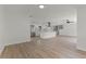 Bright, open-concept living space featuring wood floors and a modern white kitchen with stainless steel appliances at 7085 Willowwood St, Orlando, FL 32818