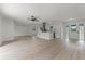 Open living room with wood laminate flooring, modern lighting, ceiling fan, and open access to the kitchen at 7085 Willowwood St, Orlando, FL 32818
