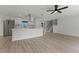 Contemporary living area with wood floors, ceiling fan, staircase, and open layout to the updated kitchen at 7085 Willowwood St, Orlando, FL 32818