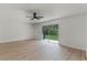 Bright living area featuring wood floors, a ceiling fan, and a large sliding glass door to the backyard at 7085 Willowwood St, Orlando, FL 32818