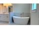 Bright bathroom with a soaking tub, dual sink vanity, and modern fixtures at 7382 Sw 129Th Ln, Ocala, FL 34473
