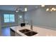 Stylish kitchen island with stainless steel sink and faucet, with view of dining/living area at 7382 Sw 129Th Ln, Ocala, FL 34473