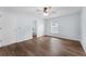 Bright and airy bedroom featuring hardwood floors, a ceiling fan, white trim, and a view into the bathroom at 7998 Harbor Bend Cir, Orlando, FL 32822