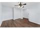Cozy bedroom with light blue walls, wood-look floors, ceiling fan, closet, and an open door to the bathroom at 7998 Harbor Bend Cir, Orlando, FL 32822