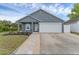 Charming single-story home with gray stucco exterior, well-manicured lawn and attached white two car garage at 7998 Harbor Bend Cir, Orlando, FL 32822