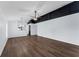 Bright open-concept living room with wood-look flooring, ceiling fan, and stylish black accent wall details at 7998 Harbor Bend Cir, Orlando, FL 32822