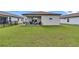 An expansive lawn leads to a cozy, covered patio, enhancing outdoor relaxation and entertainment at 8413 Sw 54Th Loop, Ocala, FL 34481