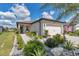 Attractive single-story home with a two-car garage and desert landscaping, complemented by an American flag at 8413 Sw 54Th Loop, Ocala, FL 34481