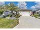 Charming single-story home featuring a two-car garage, well-manicured landscaping, and a lovely palm tree at 8413 Sw 54Th Loop, Ocala, FL 34481