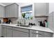 Bright kitchen counter with stainless sink, marble tile backsplash, and window view at 8413 Sw 54Th Loop, Ocala, FL 34481