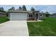 Well-maintained single-Gathering home featuring a two-car garage and a lush green lawn at 851 Marion Oaks Mnr, Ocala, FL 34473