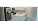 Modern kitchen with stainless steel appliances, a large center island with a sink, and sleek white cabinetry at 851 Marion Oaks Mnr, Ocala, FL 34473