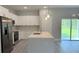 Bright kitchen with white cabinets, stainless steel appliances, and a large island, seamlessly connected to the living space at 851 Marion Oaks Mnr, Ocala, FL 34473