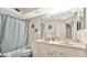 Bathroom featuring a dual-sink vanity, large mirror, and shower with a calming blue curtain at 12220 Wild Iris Way # 103, Orlando, FL 32837