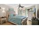 Bright bedroom with a tufted headboard, ceiling fan, large windows, and a curated display of decor at 12220 Wild Iris Way # 103, Orlando, FL 32837