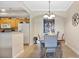 The dining room has an adjacent kitchen, a light-colored table with seating for six, and decorative lighting at 12220 Wild Iris Way # 103, Orlando, FL 32837