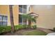 Exterior side view of condominium with covered and screened patios, surrounded by lush greenery at 12220 Wild Iris Way # 103, Orlando, FL 32837