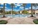 Resort-style community pool featuring palm trees and a paver deck surrounded by well-maintained landscaping at 12220 Wild Iris Way # 103, Orlando, FL 32837