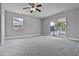 Primary bedroom with neutral carpet, ceiling fan, and sliding doors to patio at 123 Tuxpan Ln, Kissimmee, FL 34743